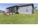 Well-maintained backyard featuring a screened-in porch, lush green lawn, and landscaped flower beds at 17204 Se 112Th Court Rd, Summerfield, FL 34491