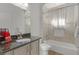 Well-lit bathroom with a shower over the tub, updated vanity and granite countertop, and tiled walls at 17204 Se 112Th Court Rd, Summerfield, FL 34491