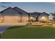 Well-lit single-story home with three-car garage, stone accents, and manicured front lawn at 17204 Se 112Th Court Rd, Summerfield, FL 34491