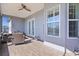 Relaxing covered patio with wicker seating, tile flooring, ceiling fan, and peaceful outdoor setting at 17204 Se 112Th Court Rd, Summerfield, FL 34491