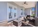 Inviting covered patio with comfortable wicker furniture, ceiling fan, and serene outdoor views at 17204 Se 112Th Court Rd, Summerfield, FL 34491