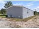 Rear exterior view with gray vinyl siding, AC unit, and well-maintained lawn showing the property's efficient design at 17442 Eve Dr, Montverde, FL 34756