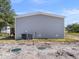 View of home's exterior showing the AC unit, septic tanks, gray vinyl siding, and well-maintained outdoor space at 17442 Eve Dr, Montverde, FL 34756