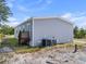 Rear exterior view of home featuring vinyl siding, AC unit, small porch, and a well-maintained lawn at 17442 Eve Dr, Montverde, FL 34756