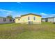 View of the home's yellow exterior, well maintained lawn and brick foundation at 1854 W Schwartz Blvd, Lady Lake, FL 32159