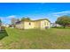 A yellow home with a well-manicured lawn and greenery under a blue sky at 1854 W Schwartz Blvd, Lady Lake, FL 32159