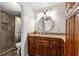Bathroom features wood cabinets, granite countertops, and a tiled walk-in shower at 1854 W Schwartz Blvd, Lady Lake, FL 32159
