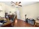 Bedroom features a ceiling fan, wood floors, and a window with blinds at 1854 W Schwartz Blvd, Lady Lake, FL 32159