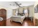 Comfortable bedroom with a ceiling fan, wood floors, and a warm atmosphere at 1854 W Schwartz Blvd, Lady Lake, FL 32159