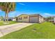Single-story home with bright green front lawn, concrete driveway, and covered carport at 1854 W Schwartz Blvd, Lady Lake, FL 32159