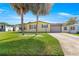 Charming single-story home featuring a well-manicured lawn and beautiful palm trees enhancing curb appeal at 1854 W Schwartz Blvd, Lady Lake, FL 32159