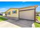 This single-story home has a covered garage with a tan-colored awning and concrete driveway at 1854 W Schwartz Blvd, Lady Lake, FL 32159