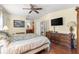 Main bedroom features a ceiling fan, wood floors, and ensuite bath at 1854 W Schwartz Blvd, Lady Lake, FL 32159