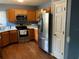 Functional kitchen featuring stainless steel appliances, wood cabinets, and laminate floor at 2001 Donnelly Pl, Mount Dora, FL 32757