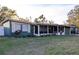 A cozy one-story home featuring a covered porch, well-manicured lawn, and low shrubbery in front of the home at 2026 Sunset Ln, Clermont, FL 34711