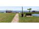 Scenic lakeside park with a picturesque walkway, wooden bench, and covered dock for enjoying the waterfront views at 2229 Cypress Ct # C-4, Tavares, FL 32778
