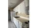 Galley kitchen with white cabinets, white appliances and solid surface countertops at 2229 Cypress Ct # C-4, Tavares, FL 32778