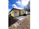 Image of a yellow house with a concrete and brick patio, gravel landscaping, and a well-manicured lawn at 224 Westwood Dr, Leesburg, FL 34748