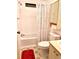 Cozy bathroom features a shower-tub combination, and ample storage with wicker shelving above the toilet at 224 Westwood Dr, Leesburg, FL 34748