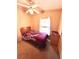 Compact bedroom featuring a ceiling fan, window, and closet at 224 Westwood Dr, Leesburg, FL 34748