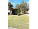 Single-story home with a covered carport, screened porch, and spacious green lawn at 224 Westwood Dr, Leesburg, FL 34748