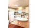 Functional kitchen with white appliances, ample cabinet space, and tile flooring at 224 Westwood Dr, Leesburg, FL 34748