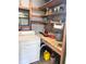 Interior laundry room featuring overhead shelving, work bench, and a large window providing natural light at 224 Westwood Dr, Leesburg, FL 34748