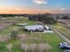 Expansive aerial view of a gray home on acreage with large trees and a long drive at 2289 Se 110Th Ave, Webster, FL 33597