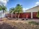 Well-maintained backyard with rock ground cover, a variety of potted plants, and mature palm trees at 2367 Camden Ter, The Villages, FL 32162
