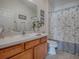Bathroom featuring a wooden vanity, ample counter space, and a shower/tub combo at 2367 Camden Ter, The Villages, FL 32162
