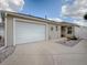 A home's exterior featuring a spacious two-car garage, manicured landscaping, and neutral siding at 2367 Camden Ter, The Villages, FL 32162