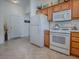 Efficient kitchen layout with classic white appliances and ample cabinet space, ideal for culinary enthusiasts at 2367 Camden Ter, The Villages, FL 32162