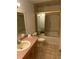 Bathroom featuring a vanity, toilet, and tiled shower with gold accents at 2416 Spring Lake Rd, Fruitland Park, FL 34731