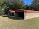 Two metal carports with a red roof on a large lot offering ample space for parking and storage at 2416 Spring Lake Rd, Fruitland Park, FL 34731