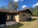 Exterior back view showcases brickwork, gutters, and fenced yard, highlighting home's practical features and design at 2416 Spring Lake Rd, Fruitland Park, FL 34731