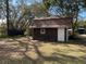 Exterior of a brown shed with a metal roof, a single window, and a white entry door at 2416 Spring Lake Rd, Fruitland Park, FL 34731