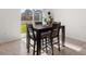 Sunlit dining area with a dark wood table and a view of the backyard through sliding glass doors at 2510 Glacier Express Ln, Tavares, FL 32778