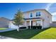 Traditional home with a manicured lawn, two-car garage, and cozy front porch at 2510 Glacier Express Ln, Tavares, FL 32778