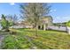 Expansive backyard featuring lush green grass, mature trees, privacy fence, and patio for outdoor enjoyment at 2727 Retriever Dr, Clermont, FL 34711