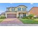 Charming two-story home featuring a brick-paved driveway, manicured lawn, and an inviting front porch at 2727 Retriever Dr, Clermont, FL 34711