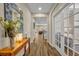 Bright hallway with wood-look flooring, decorated with a mirror and flowers, leading into the home's interior at 2727 Retriever Dr, Clermont, FL 34711
