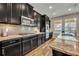Stylish kitchen with granite countertops, stainless steel appliances, and dark cabinets at 2727 Retriever Dr, Clermont, FL 34711