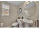 Compact powder room with a pedestal sink, toilet, and decorative accents at 2727 Retriever Dr, Clermont, FL 34711