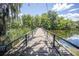 Scenic view of a wooden boardwalk over the lake, surrounded by lush foliage and a blue sky at 2886 N C 470, Lake Panasoffkee, FL 33538