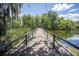 Scenic view of a wooden boardwalk over the lake, surrounded by lush foliage and a blue sky at 2886 N C 470, Lake Panasoffkee, FL 33538