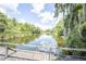 Scenic lake view with a wooden boardwalk and lush green foliage under a sunny sky with clouds at 2886 N C 470, Lake Panasoffkee, FL 33538