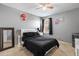 Bedroom featuring modern decor, gray walls, window with black curtains, and a queen-sized bed at 303 Red Kite Dr, Groveland, FL 34736