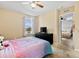 Cozy bedroom with neutral walls, ceiling fan, and ample natural light from the window at 303 Red Kite Dr, Groveland, FL 34736