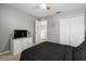 Bedroom with black bedding, carpet floors, gray walls, closet, and natural light at 303 Red Kite Dr, Groveland, FL 34736