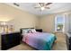 Cozy bedroom featuring a bed, ceiling fan, and natural light from the window at 303 Red Kite Dr, Groveland, FL 34736